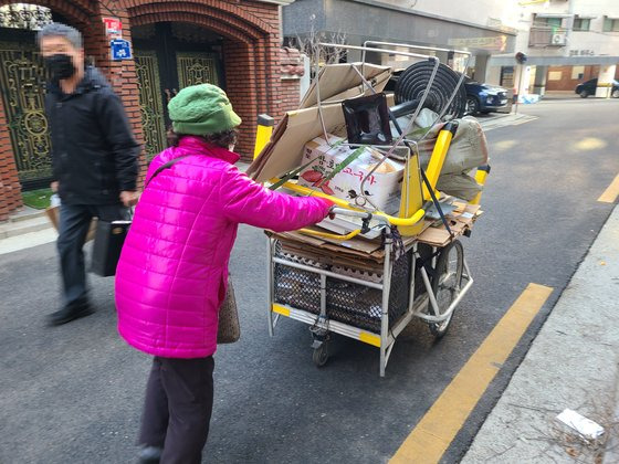 지난 11일 정 할머니가 사흘간 수집한 폐지 등을 판매하기 위해 언덕을 내려가고 있다. 이찬규 기자