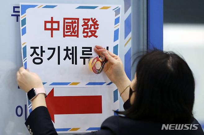 [인천공항=뉴시스] 최동준 기자 = 지난 9일 인천국제공항에서 공항 관계자가 중국발 장기체류자 입국장 안내문을 붙이고 있는 모습. 2023.01.18. photocdj@newsis.com