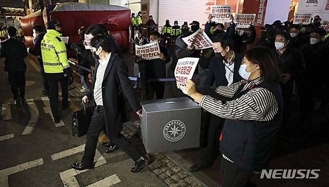 [서울=뉴시스] 최진석 기자 = '간첩단 의혹'과 관련해 압수수색을 마친 국가정보원 관계자들이 18일 오후 서울 정동 민주노총에서 압수물품을 들고 나오고 있다. 2023.01.18. myjs@newsis.com