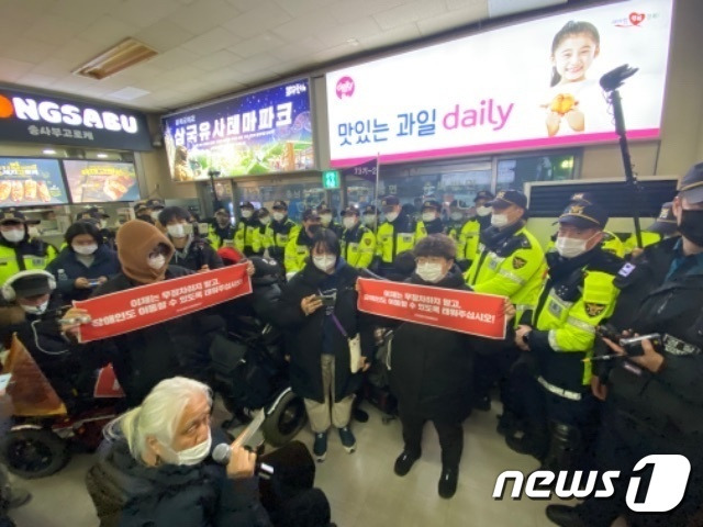 19일 오후 서울남부터미널 앞에서 시외버스를 타기 위해 전국장애인차별철폐연대(전장연) 회원들과 경찰이 대치하는 모습.ⓒ (전장연 제공)