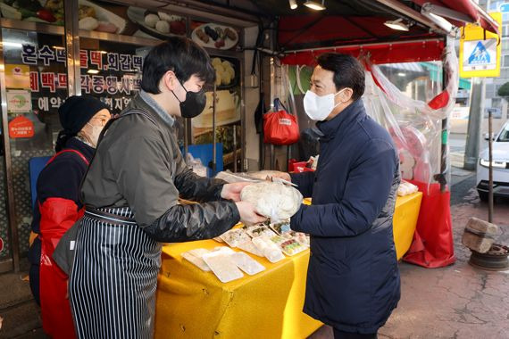 김충배 신용보증기금 전무이사가 대구 반야월 목련시장을 방문해 설맞이 어르신을 위한 ‘사랑의 명절음식’ 물품을 구매하고 있다. 신보제공