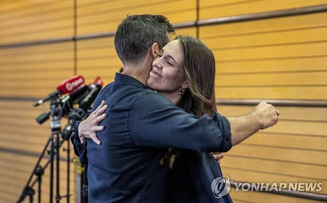 사임 발표후 포옹하는 아던 총리와 배우자  [AP=연합뉴스]