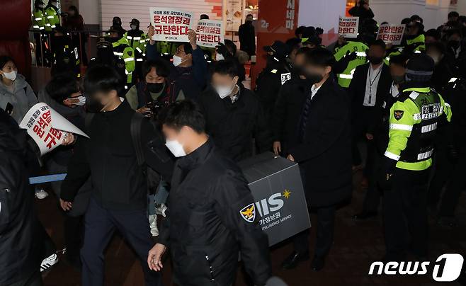 국가정보원 관계자들이 18일 오후 서울 중구 전국민주노동조합총연맹(민주노총) 서울 사무실에서 국가보안법 위반 혐의로 압수수색을 마친 후 압수품 상자를 들고 나가고 있다. 2023.1.18/뉴스1 ⓒ News1 이동해 기자