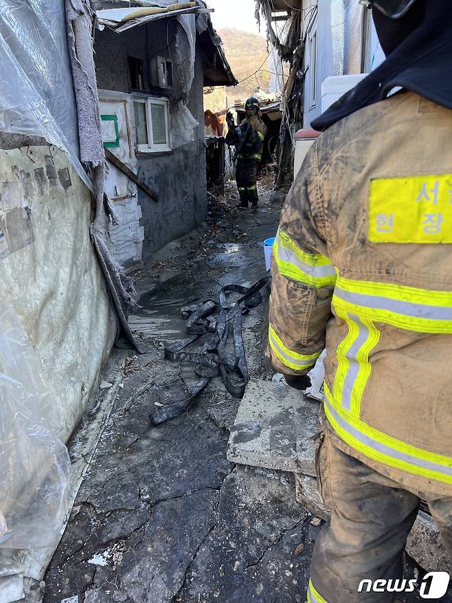구룡마을 화재 현장에서 걷어온 소방호스와 이를 정리하는 소방관들의 방화복 역시 검댕 투성이었다. 2023.01.20./뉴스1 ⓒNews1 김정현 기자