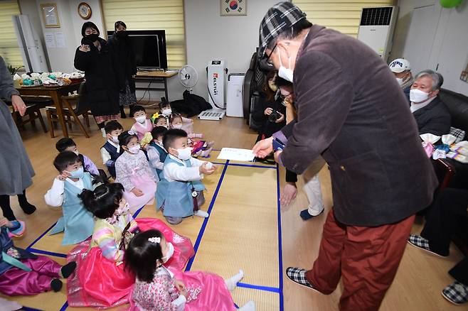 구립 삼성아트 어린이집 어린이들이 17일 서울 송파구 문정 래미안 아파트 경로당을 찾아 합동 세배를 마친 뒤 어르신에게 세뱃돈을 받고 있다./뉴스1 제공