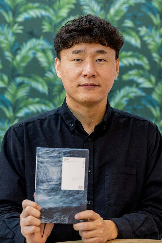 정대건 작가가 2023년 1월10일 서울 공덕동 한겨레신문사 회의실에서 신간 <급류>를 들고 카메라를 바라보고 있다. 박승화 선임기자