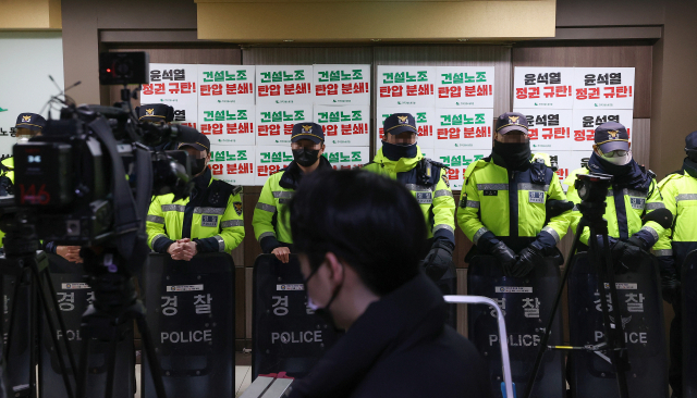 서울경찰청 강력범죄수사대가 건설현장 불법행위와 관련해 양대노총 건설노조를 압수수색한 지난 19일 오전 서울 영등포구 민주노총 건설노조 서울경기북부지부 사무실 앞에 도열해 있다./연합뉴스