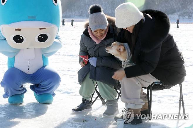 '잘 낚아보시개' (인제=연합뉴스) 박영서 기자 = 제23회 인제빙어축제 개막 이틀째인 21일 축제장인 강원 인제군 남면 빙어호에서 관광객들이 반려견과 함께 얼음낚시를 즐기고 있다. 이번 축제는 오는 29일까지 이어진다. 2023.1.21 conanys@yna.co.kr