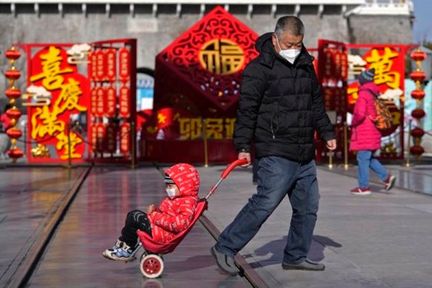 지난해 중국인구가 저출산 여파로 61년만에 처음으로 감소한 가운데 17일 중국 베이징의 첸먼다제(前門大街) 거리에서 한 남성이 아이가 탄 유모차를 끌고 가고 있다. ⓒ AP/연합뉴스
