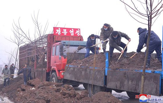 북한 내각 경공업성 관계자들의 평양 인근의 협통농장에 자신들이 모은 퇴비를 하역하는 모습. 조선중앙통신, 연합뉴스