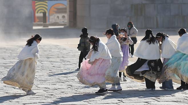 한파특보가 발령된 24일 오후 경복궁을 찾은 관광객들이 바람을 맞으며 걷고 있다. 2023.1.24 /연합뉴스