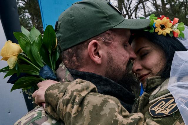 우크라이나 군 의무병 유지니아(오른쪽)와 올렉산드르가 지난해 12월 24일 도네츠크 지역 라이만에서 결혼식을 마친 뒤 포옹하고 있다. 라이만=AP 연합뉴스