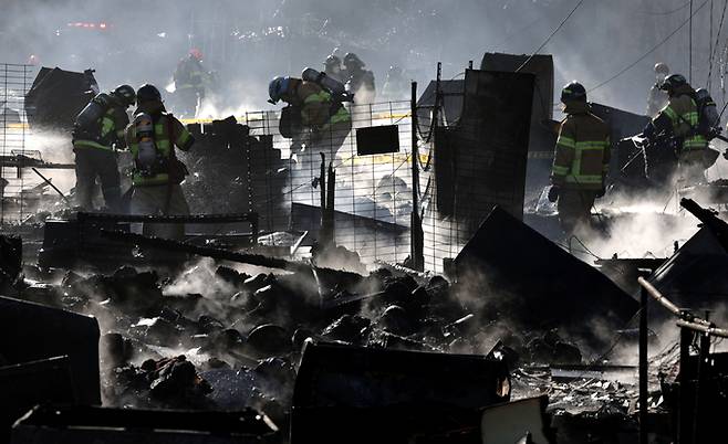 지난 20일 화재가 발생한 서울 강남구 개포동 구룡마을 4구역에서 소방대원들이 잔불 정리를 하고 있는 모습. 연합뉴스