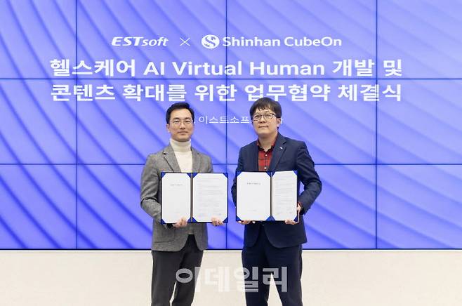정상원 이스트소프트 대표(왼쪽)와 이용범 신한큐브온 대표가 업무협약 체결 후 이스트소프트가 제작한 AI 버추얼 휴먼과 함께 기념 촬영을 하고 있다.
