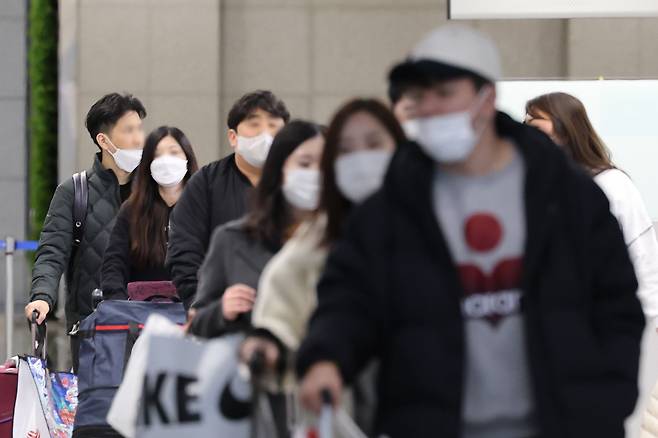 지난 24일 인천공항에서 마스크를 쓴 여행객들이 이동하고 있다. /연합뉴스