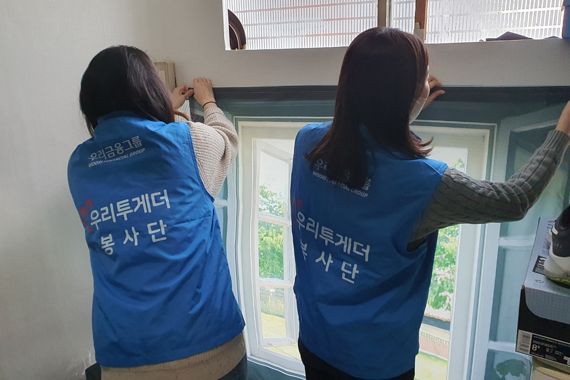 우리금융미래재단 직원들이 18일 서울 용산구 쪽방촌을 찾아 주민들을 위해 방한커튼을 설치하고 있다. 우리은행 제공.