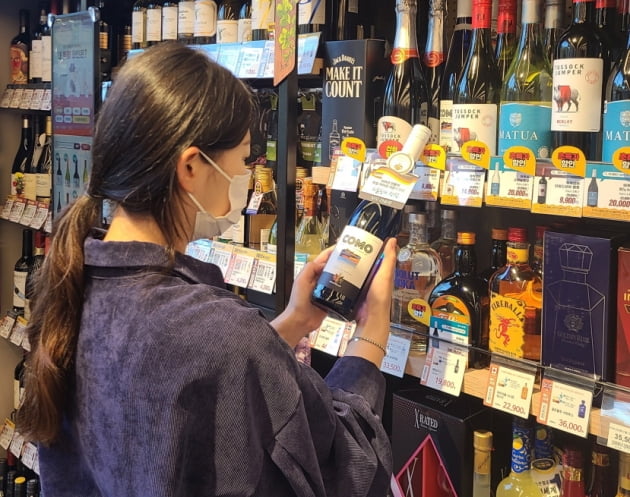 고객이 이마트24 매장에서 와인 상품을 살펴보고 있다./사진=이마트24 제공