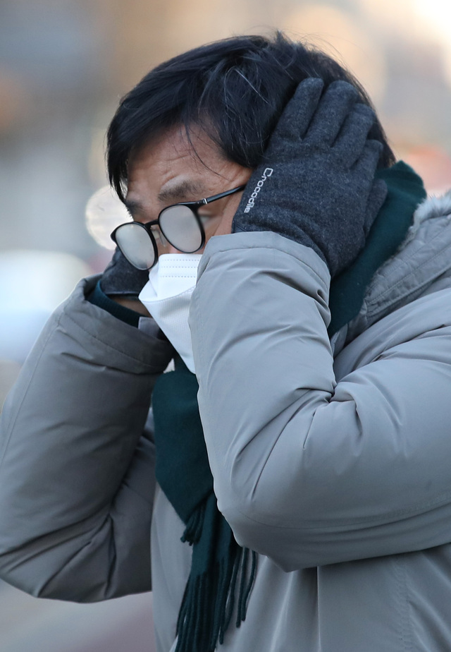 25일 오전 서울 광화문네거리에서 시민이 양손으로 귀를 녹이고 있다. 이날 서울 아침 최저 기온이 영하 18도까지 떨어지는 등 전국 대부분의 지역에 한파특보가 발효됐다. 뉴시스