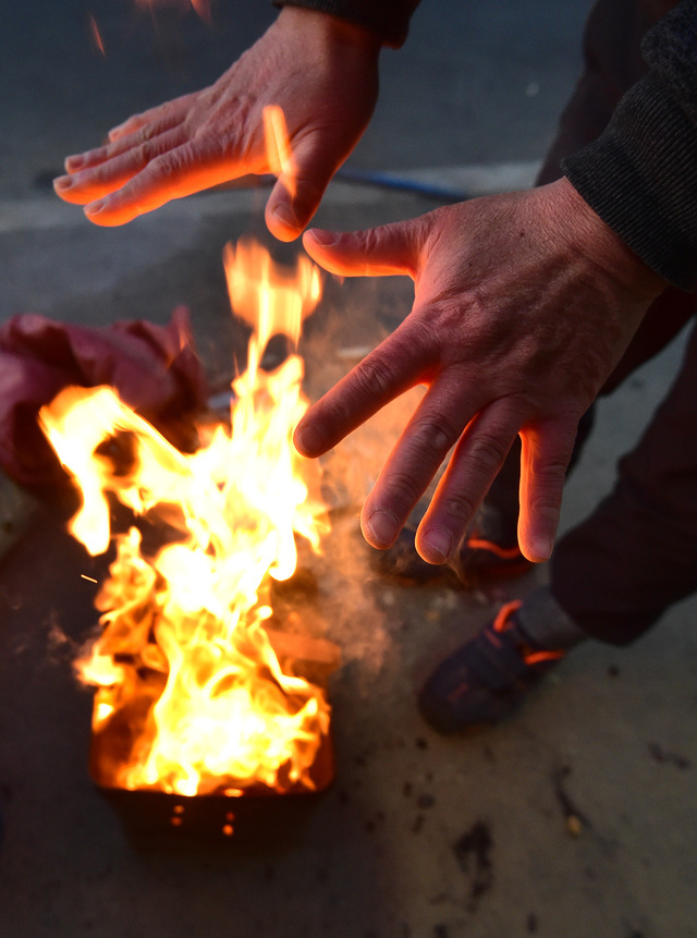 전국에 기온이 뚝 떨어지며 추운날씨를 보인 25일 오전 대구 북구 칠성시장에서 한 상인이 모닥불을 쬐고 있다. 뉴시스