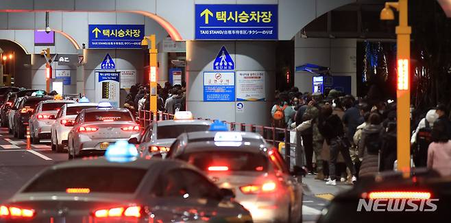 [제주=뉴시스] 우장호 기자 = 제주공항 셧다운 여파로 귀경 행렬이 이어지는 25일 오후 공항 택시승강장이 늦은 시간임에도 불구하고 이용객들로 크게 붐비고 있다. 국토교통부는 결항 사태로 발이 묶인 체류객 수송을 위해 오는 26일 오전 1시까지 김포공항 이착륙 시간을 연장했다. 2023.01.25. woo1223@newsis.com