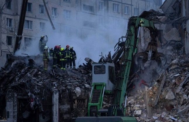 지난 15일 우크라이나 남동부 도시 드니프로의 한 아파트에서 구조대원들이 건물 잔해를 치우고 있다. ⓒAP/뉴시스