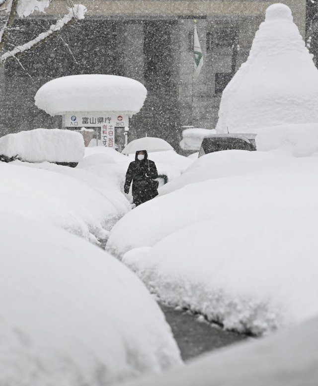 일본 도야마에 기록적인 폭설이 이어진 가운데 11일 우산 쓴 한 시민이 허리 높이까지 눈이 쌓인 거리를 걷고 있다. 도야마는 지난 7일 이후 내린 폭설로 122cm의 적설량을 기록했으며 주변 지역에 평년 대비 2~10배 많은 눈이 내리고 8명이 사망했다고 기상청이 밝혔다. 2021.01.11. 도야마=AP/뉴시스