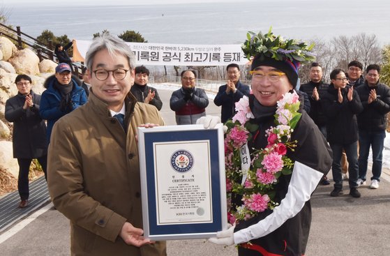 조웅래 회장(오른쪽)이 116일 동안 518시간 57분 59초만에 대한민국 국토 경계 한 바퀴를 돌아 다시 통일전망대에 도착한 후 김덕은 한국기록원 원장으로부터 인증서를 전달 받고 있다. 사진 맥키스컴퍼니