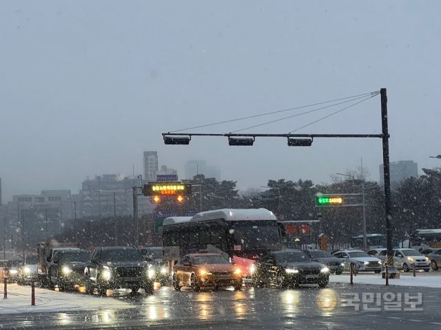 서울 등 중부지방을 중심으로 많은 눈이 내린 26일  서울 영등포구 여의도역에서 차량들이 거북이 운행을 하고 있다.