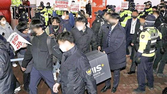 국가정보원 관계자들이 지난 18일 오후 서울 정동 민주노총 서울 사무실에서 압수수색을 마친 후 건물에서 나오고 있다. 뉴스1