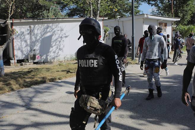 26일(현지 시각) 아이티 수도 포르토프랭스에서 경찰관 시위대가 무기를 든 채 이동하고 있다. 이들은 동료 경찰관이 갱단에 희생된 것에 분노해 시위에 나섰다. /로이터 뉴스1