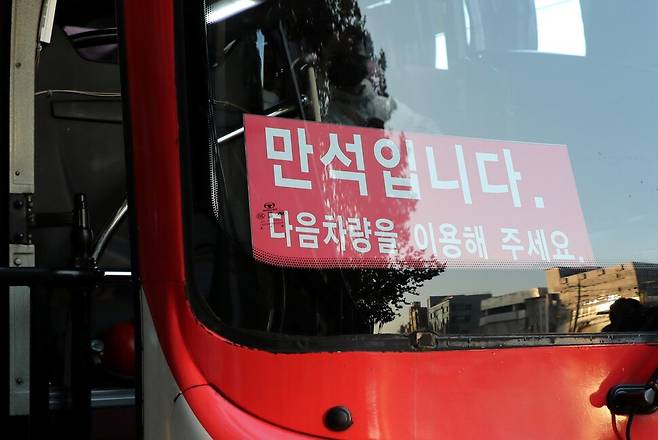 광역버스 입석승차가 중단된 2022년 11월18일 오전 경기도 수원시의 한 버스정류장에 ‘만석입니다’라는 문구가 부착된 버스가 지나가고 있다. 연합뉴스