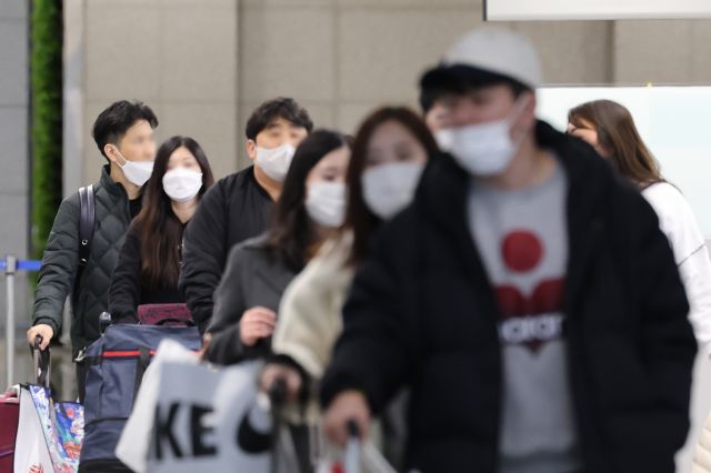 마스크를 착용한 여행객들이 지난 24일 인천공항에서 짐가방을 끌고 이동하고 있다. 연합뉴스
