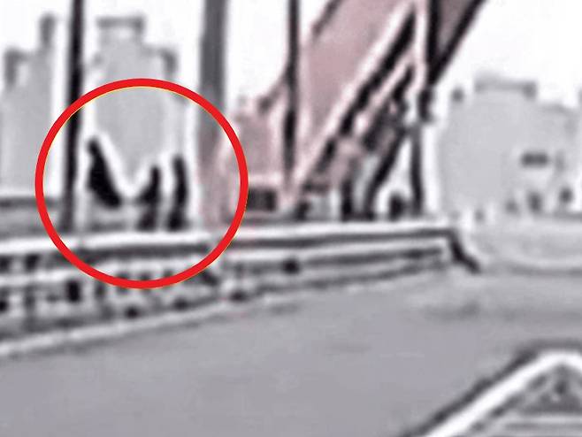 지난해 11월 서강대교 난간 위에 앉아 있는 20대 여성을 구하기 위해 시민들이 다가서고 있다. [한문철TV]