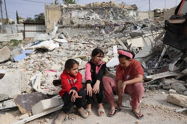 팔레스타인 소녀들이 29일 이스라엘 불도저가 밀어버려 폐허가 된 집 터에 앉아있다. 동예루살렘/AFP 연합뉴스
