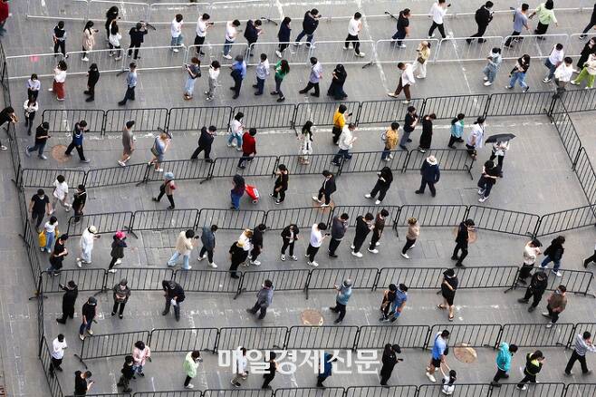 중국 19개 부처는 후커우 제도를 개선해 농민공 복지를 향상시키겠다고 28일 밝혔다. 사진은 지난해 베이징의 코로나19검사소 앞에 검사를 기다리는 사람들이 늘어선 모습.