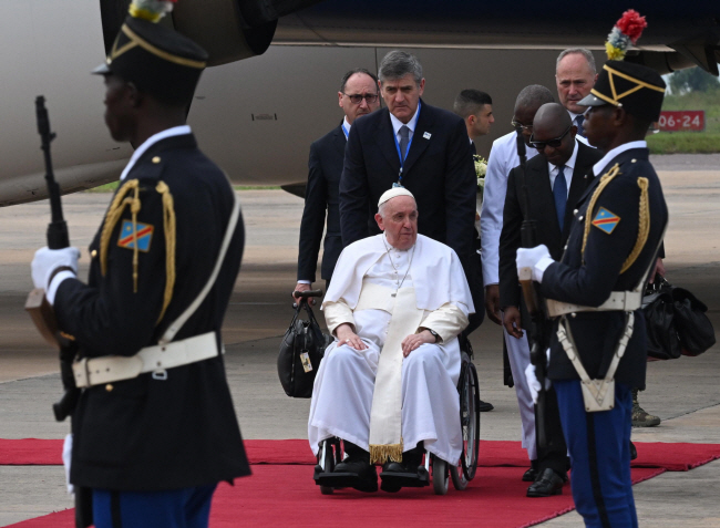 프란치스코 교황(가운데)이 1월 31일 콩고민주공화국 킨샤사 인근 은질리 국제공항에 도착해 휠체어에 몸을 의지한 채 이동하고 있다.   EPA 연합뉴스