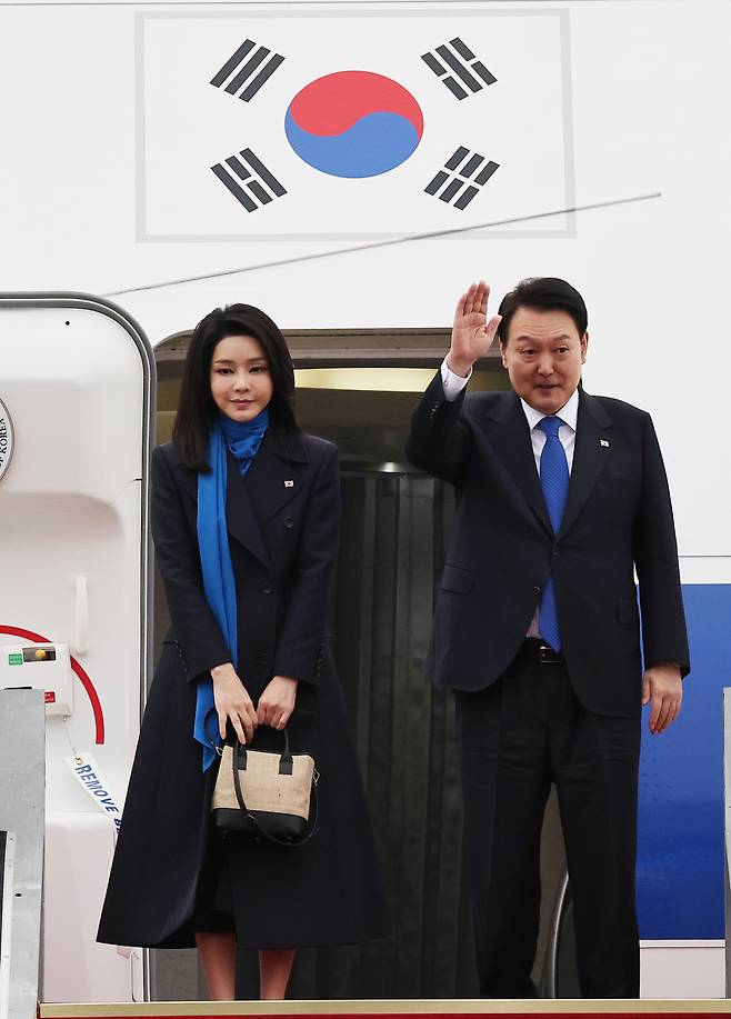 김건희(왼쪽) 여사가 최근 윤석열 대통령과 스위스 다보스포럼 참석 등을 위해 경기도 성남 서울공항에서 탑승 전 인사를 할 때 들었던 가방은 커피 자루와 비건 한지 소재로 만든 업사이클링 친환경 브랜드 할리케이의 ‘비니 백’이다. [연합]