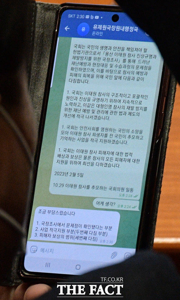 송언석 국민의힘 의원이 국회 본회의장에서 10.29 이태원 참사를 추모하는 국회의원 일동의 '국회의 다짐' 초안을 두고 당직자와의 메시지를 확인하는 모습.