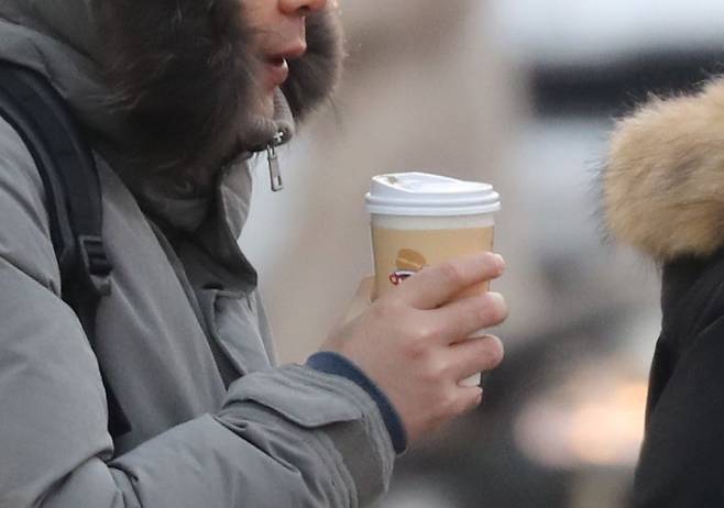 지난해 12월 26일 오전 서울 종로구 광화문광장 일대에서 한 시민이 따뜻한 커피를 들고 걸어가고 있다./뉴스1
