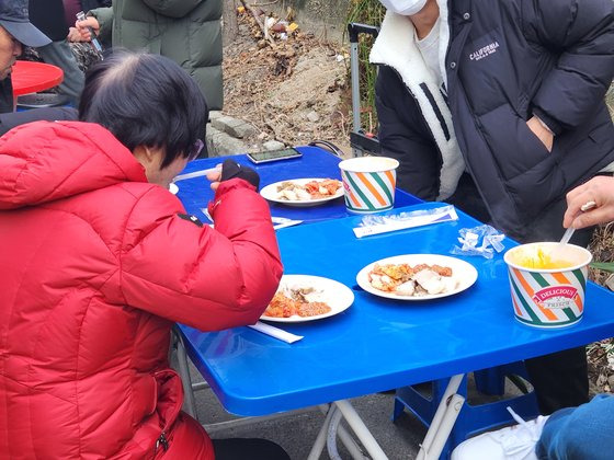 2일 오후 대구 북구 대현동 경북대학교 서문 인근 골목가에서 돼지고기 수육과 소고기국밥을 받은 사람들이 식사를 하고 있다. 이날 돼지고기 잔치는 이슬람 사원 건립을 반대하는 대현동 주민 중 일부가 주최했다. 김정석 기자