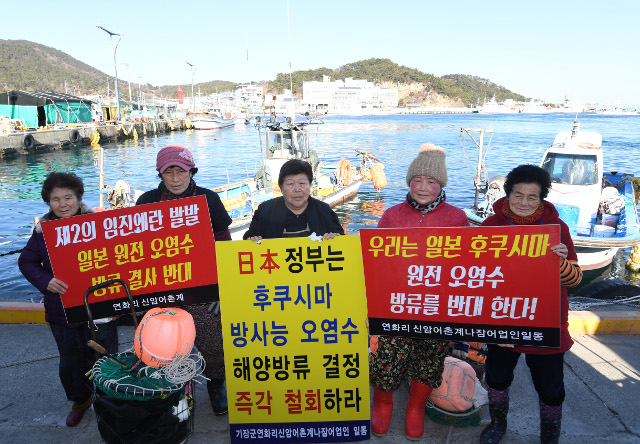 부산 기장군 연화리 신암어촌계 해녀들이 지난달 30일, 2021년 일본의 원전 오염수 배출 발표 당시 1인 시위를 진행했던 피켓을 들고 바다 앞에 서있다. 부산=이한형 기자