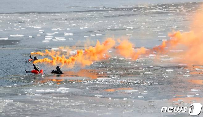 3일 오후 충북 진천군 초평저수지에서 열린 공군의 혹한기 항공구조사 구조작전 훈련에서 얼어붙은 호수에 조난된 조종사들이 신호탄을 터트리며 공군 제6탐색구조비행전대에 구조요청을 하고 있다. 2023.2.3/뉴스1 ⓒ News1 김기남 기자