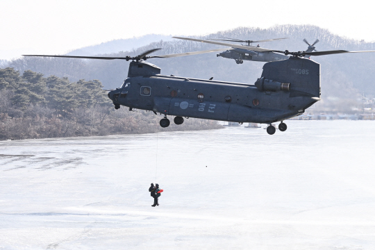 HH-47 탐색구조헬기(앞)가 3일 충북 진천군 초평저수지에서 구조용 인양기(HOIST)로 조난자 구조 훈련을 하고 있다. 공군 제공