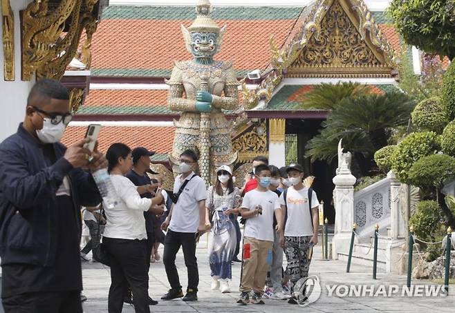 epa10397722 Chinese tourists visit the Temple of the Emerald Buddha, one of Bangkok's most popular tourist attractions, in Bangkok, Thailand, 10 January 2023. Thailand welcomed the return of Chinese tourists without special COVID-19 health restrictions, aimed to boost the country's economy and recover the tourism industry after China's easing of travel restrictions. Thailand is projected to welcome at least 300,000 Chinese tourists in the first quarter of 2023, and earlier forecast projected 20 million foreign arrivals before raising the figure to 25 million after China lifted its COVID-19 measures and relaxed its zero-COVID policy, according to the Tourism Authority of Thailand. EPA/NARONG SANGNAK /사진=연합뉴스