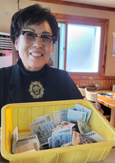 청주에서 ‘만나김치식당’을 운영하는 박영숙씨가 1000원짜리 지폐가 담긴 바구니를 들어보이고 있다.