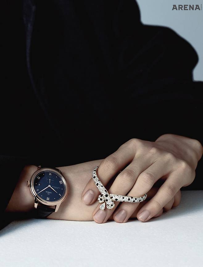 세드나 골드로 통일한 케이스와 핸즈, 로마숫자와 카보숑 인덱스에 3시 방향의 날짜창, 6시 방향의 스몰 세컨즈 디스플레이로 간결하게 구성한 드 빌 프레스티지 코-액시얼 마스터 크로노미터 스몰 세컨즈 41mm 1천6백만원대 오메가, 블랙 스피넬과 파베 세팅 다이아몬드로 오묘한 패턴을 완성하고, 중심에 페어 컷 다이아몬드를 장식한 옹브르 펠린느 브레이슬릿 가격미정 프레드 제품.