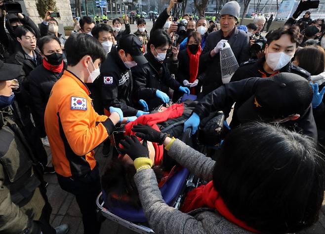 이태원 참사 희생자 유가족이 6일 서울시청 앞 광장에 마련된 시민분향소에 난로를 들이다가 경찰 인력과 충돌 후 병원에 이송되고 있다.(사진=뉴스1)