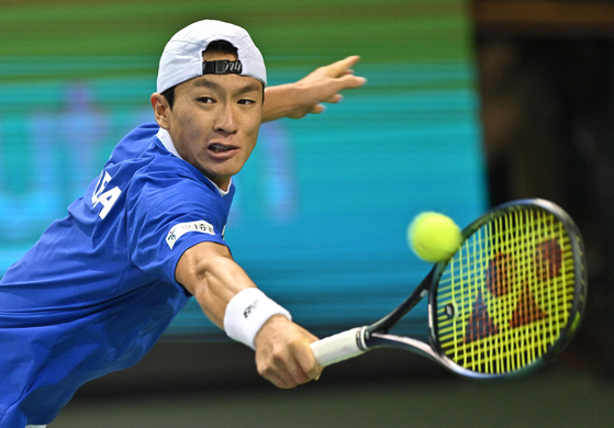 Korea's Hong Seong-chan returns the ball against Belgium's Zizou Bergs during their singles match of the Davis Cup qualifiers in Jamsil, southern Seoul on Sunday.  [AFP/YONHAP]