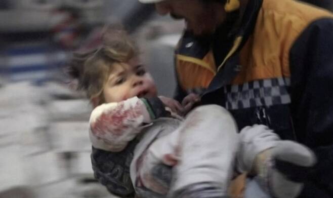 지진으로 다친 아이를 들고 뛰는 튀르키예 구조대 모습 [사진 = 연합뉴스]