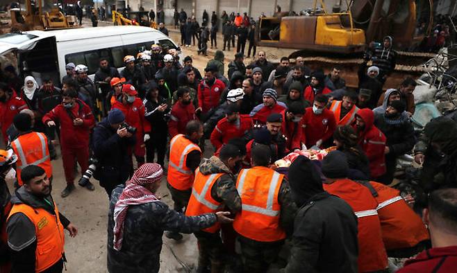 6일(현지시간) 시리아 하마에서 민방위대와 보안군이 힘을 합쳐 지진 피해자를 이송하고 있다. AP연합뉴스